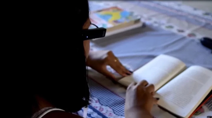 #PraTodosVerem: na imagem podemos ver Kayenne Alves usando o dispositivo com inteligência artificial para ler livros